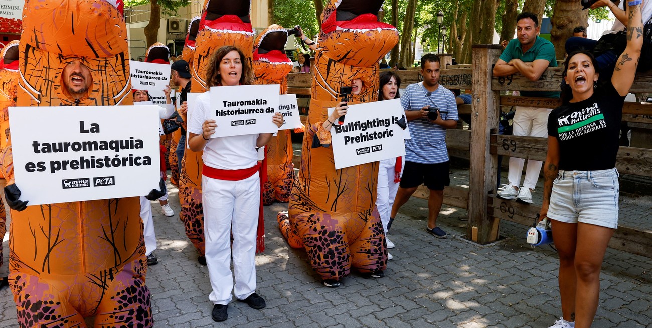 Activistas de Personas por la Ética en el Trato de los Animales (PETA) y AnimaNaturalis, vestidos como dinosaurios, participan en una manifestación contra las corridas de toros un día antes del inicio de las fiestas de San Fermín en Pamplona, España, el 5 de julio de 2022.Foto: Reuters