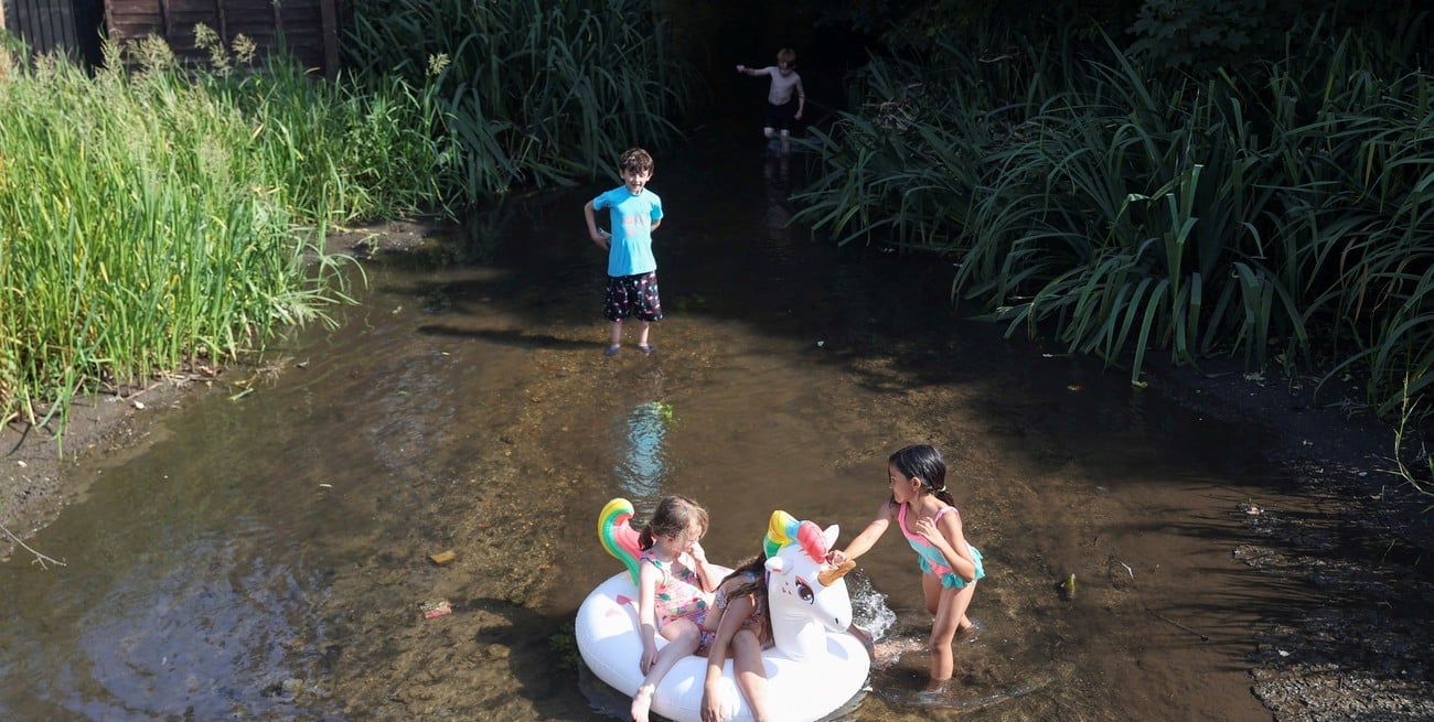 Los niños juegan en el río Ver, durante una ola de calor, en St Albans, Gran Bretaña, el 19 de julio de 2022. Foto: Reuters