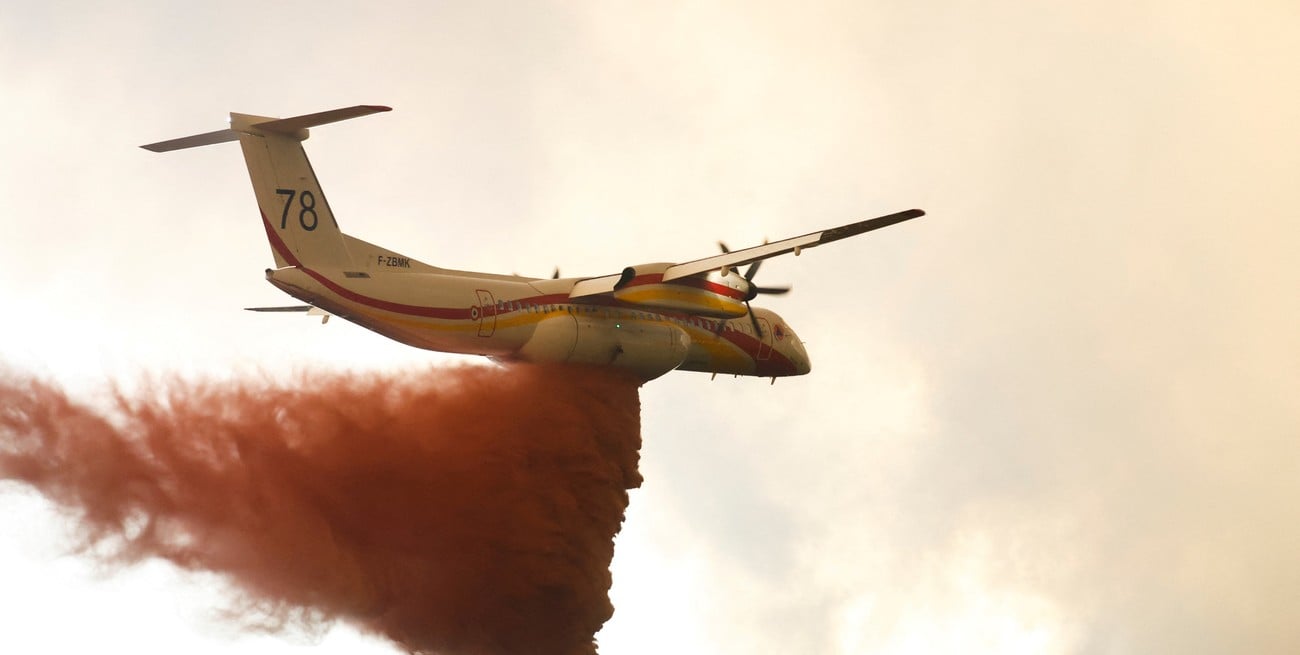 A firefighting plane drops flame retardant to extinguish a fire in Belin-Beliet, as wildfires continue to spread in the Gironde region of southwestern France, August 10, 2022. REUTERS/Stephane Mahe