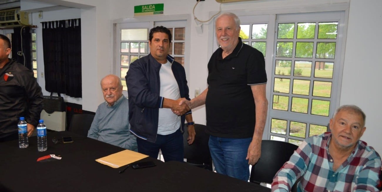 El presidente de Colón, José Vignatti, estrecha su mano con la de Marcelo Saralegui, acompañado de Patricio Fleming y Gustavo Ingaramo.