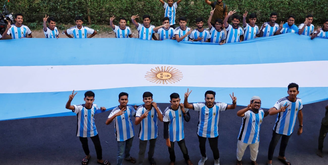 Estudiantes de la Universidad de Dhaka, que apoyan a la Scaloneta, posan para una foto con la bandera nacional de Argentina antes de la Copa Mundial de la FIFA Qatar 2022 en Dhaka, Bangladesh, el 20 de noviembre de 2022. Foto: Reuters