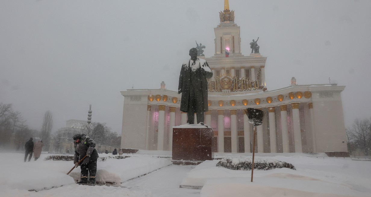 Un trabajador limpia la nieve junto a la estatua del fundador del estado soviético Vladimir Lenin durante la nevada en la Exposición de Logros de la Economía Nacional (VDNKh) en Moscú, Rusia, el 18 de diciembre de 2022. Foto: Reuters