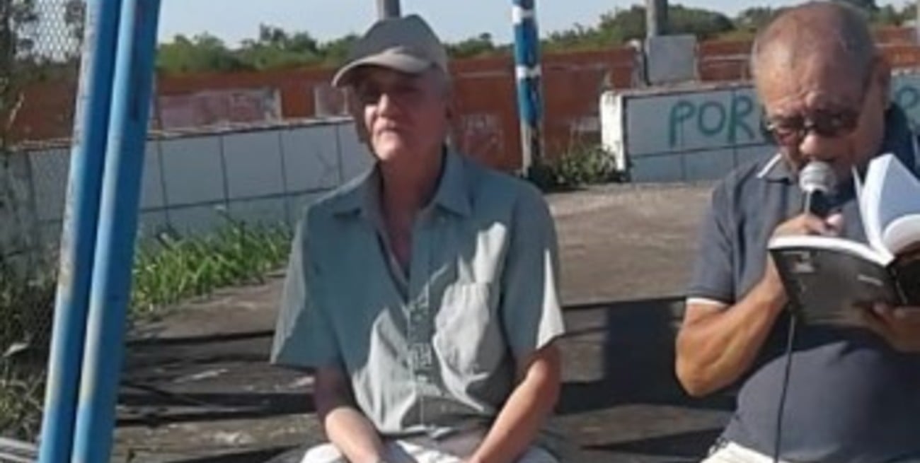 El ex comisario Ricardo Límido y Orlando Gauna (libro en mano) en el sitio donde se encuentra el monumento a Carlos Monzón, construido en el lugar en el que el ex campeón mundial de boxeo perdió la vida en 1995.