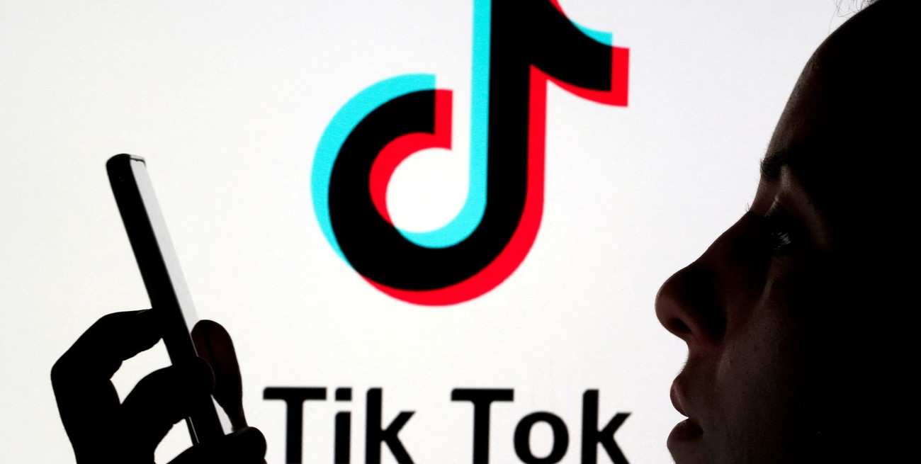 FILE PHOTO: A person holds a smartphone as Tik Tok logo is displayed behind in this picture illustration taken November 7, 2019. Picture taken November 7, 2019. REUTERS/Dado Ruvic/Illustration/File Photo