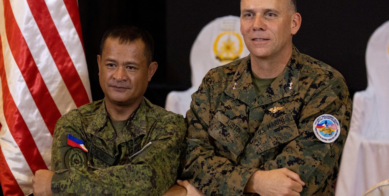 El Director del Ejercicio de Filipinas, el General de División Marvin Licudine, enlaza los brazos con el Representante del Director del Ejercicio de EE. UU., el General de División Eric Austin. Crédito: Eloisa Lopez / Reuters