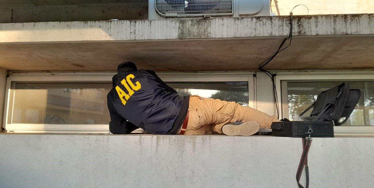 Un experto buscando rastros en las aberturas de uno de los inmuebles siniestrados. FOTO: El Litoral