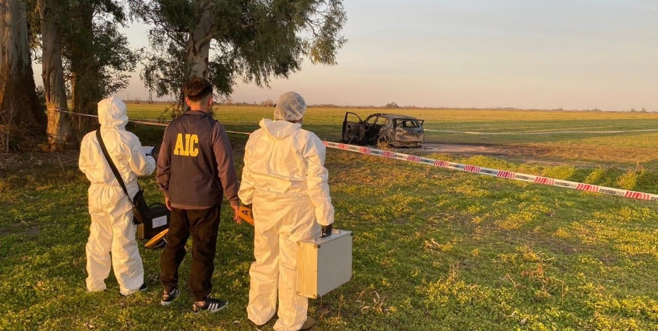 Peritos de AIC y Bomberos trabajan en la escena del doble crimen en zona rural de Gálvez, en el departamento San Jerónimo.
