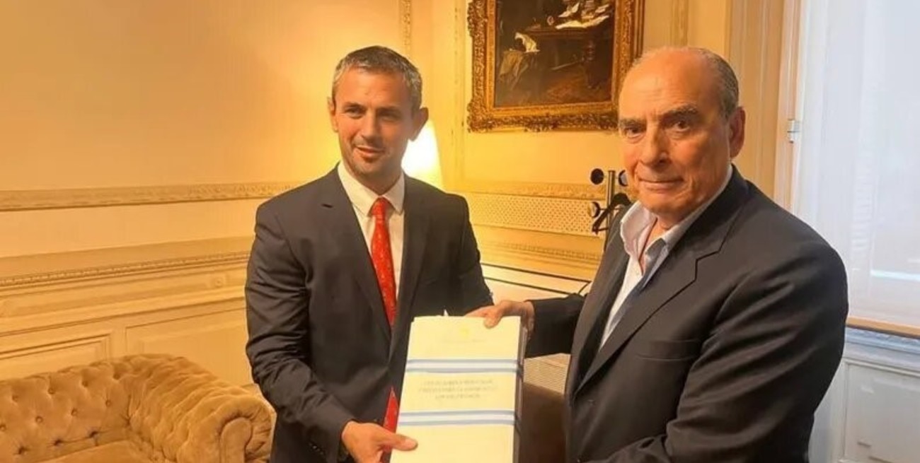 Martín Menem y Guillermo Francos exhibiendo el texto original de la ley ómnibus.