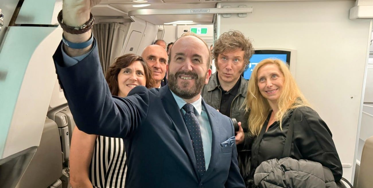 El presidente Javier Milei y su hermana Karina, con parte de la tripulación que se encuentra a bordo del avión de línea en el que partieron hacia Roma.