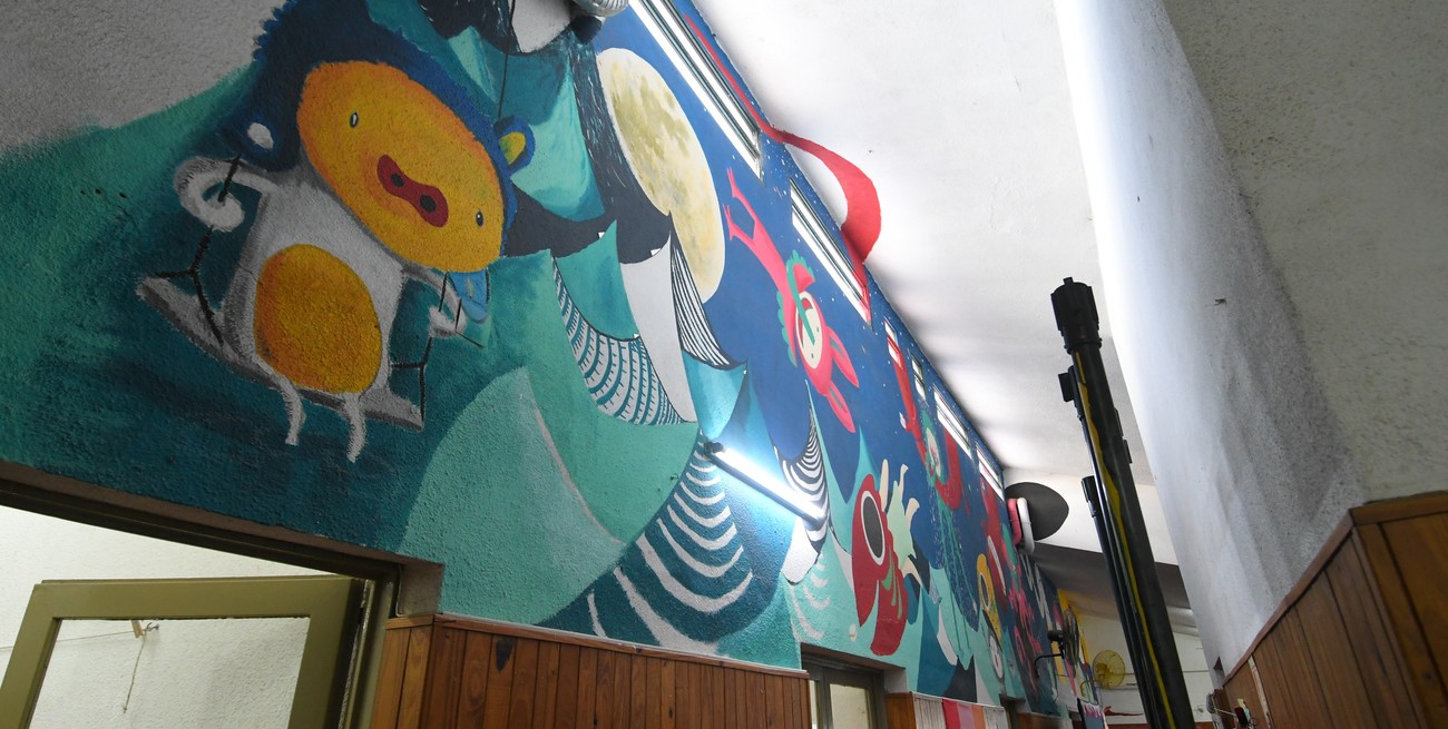 MURAL. a partir de lo que los chicos iban diciendo a través del whatsapp de cuánto extrañaban el jardín, Lucas Bisotto pintó el mural dentro del edificio. Crédito: Manuel Fabatía