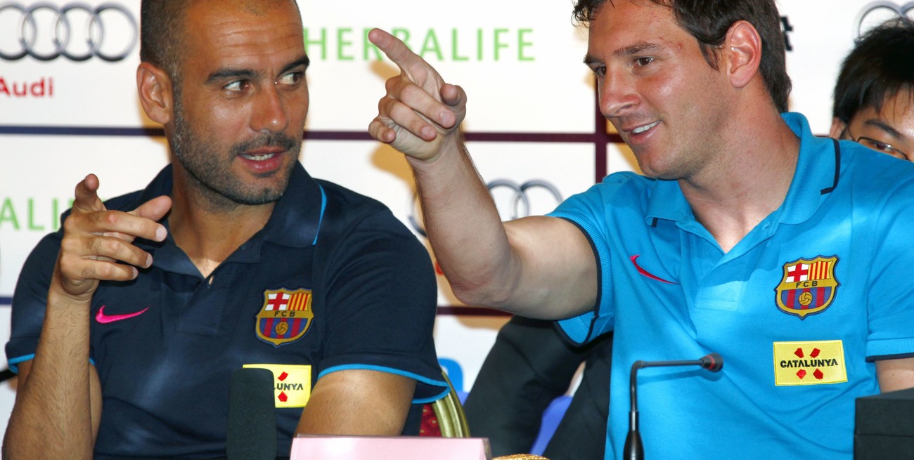 Coach of Barcelona Josep Guardiola (L) talks with his team's player Lionel Messi during a media conference in Beijing August 5, 2010. Barcelona will play Beijing Guoan in a friendly match at the National Stadium, also known as the Bird's Nest, on August 8. REUTERS/David Gray (CHINA - Tags: SPORT SOCCER) pekin china Lionel Messi Josep Pep Guardiola gira pretemporada del equipo barcelona futbol conferencia de prensa