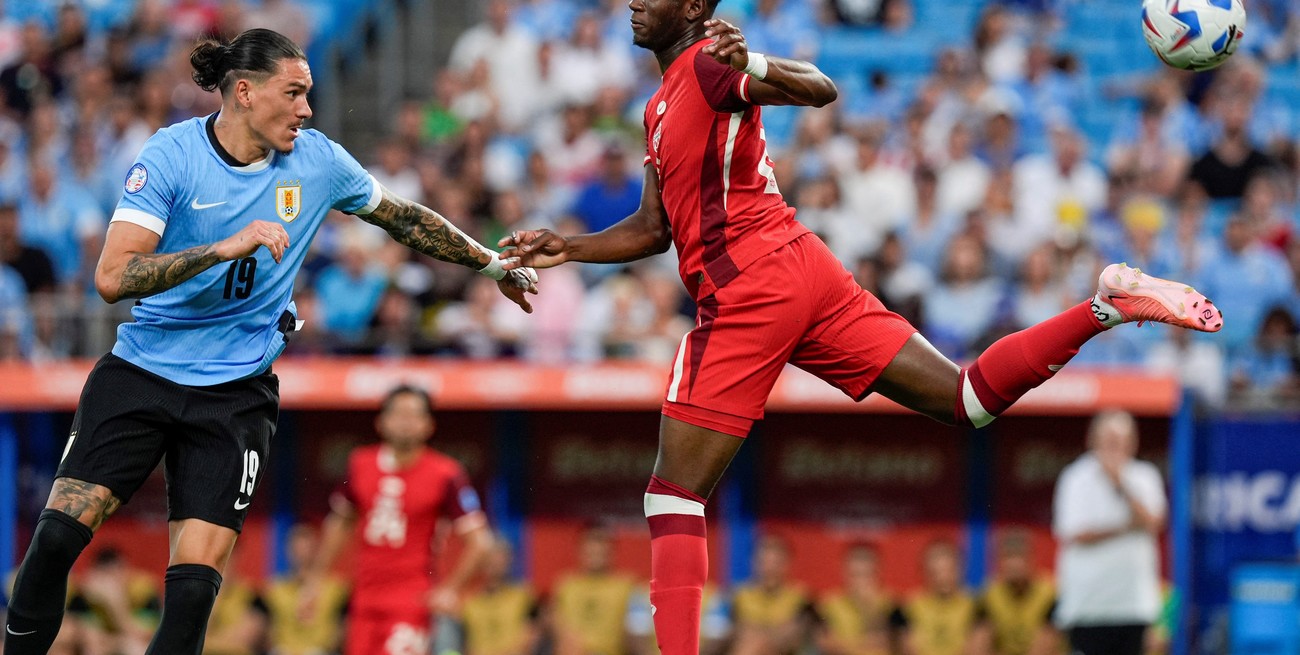 Jul 13, 2024; Charlotte, NC, USA; Canada midfielder Ismael Kone (8) reverse kicks the ball towards the goal defended by Uruguay forward Darwin Nunez (19) during the first half at Bank of America Stadium. Mandatory Credit: Jim Dedmon-USA TODAY Sports