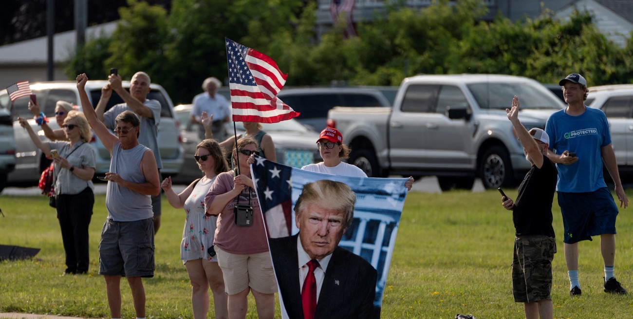 Supporters react as Trump Force One, carrying Republican presidential candidate and former U.S. President Donald Trump, lands in Milwaukee, Wisconsin, U.S., July 14, 2024 a day after he survived an assassination attempt at a rally in Butler, Pennsylvania. REUTERS/Cheney Orr