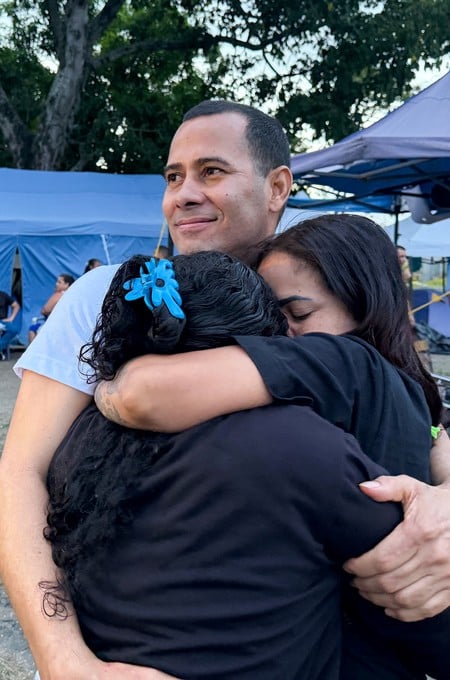 Merwin Simons Vasquez hugs loved ones after his release from El Rodeo prison under Venezuela’s government "Peace and Democratic Coexistence" program, in Guatire, Venezuela, August 14, 2026. Picture taken with a mobile phone. REUTERS/Luis Colmenares