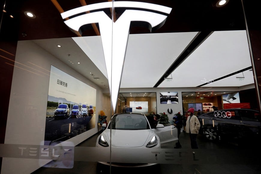 FILE PHOTO: Visitors check a Tesla Model 3 car next to a Model Y displayed at a showroom of the U.S. electric vehicle (EV) maker in Beijing, China February 4, 2023. REUTERS/Florence Lo/File Photo