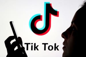 FILE PHOTO: A person holds a smartphone as Tik Tok logo is displayed behind in this picture illustration taken November 7, 2019. Picture taken November 7, 2019. REUTERS/Dado Ruvic/Illustration/File Photo