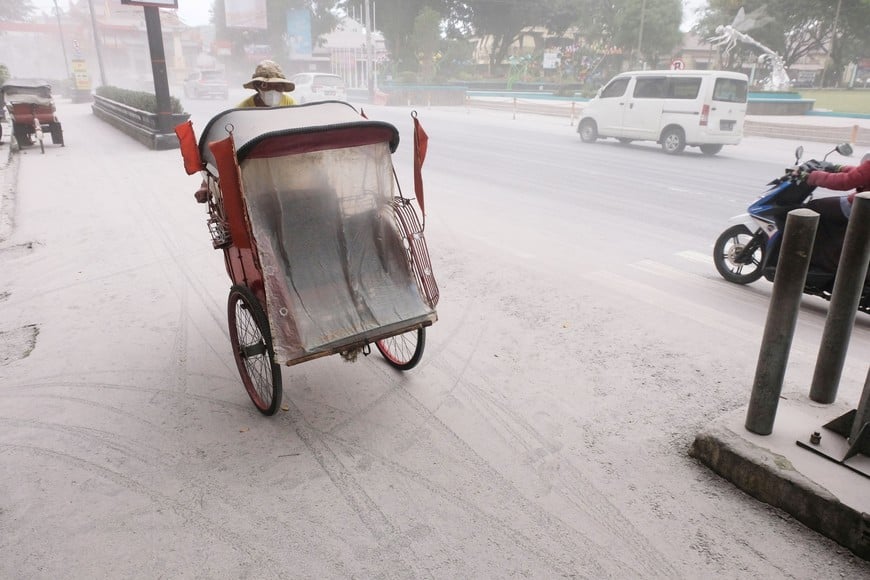 A pedicab passes on a road covered by ash from the eruption of Indonesia's Mount MerapiÊvolcano, in Magelang, Central Java province, Indonesia, March 11, 2023. Antara Foto/Anis Efizudin/via REUTERS ATTENTION EDITORS - THIS IMAGE HAS BEEN SUPPLIED BY A THIRD PARTY. MANDATORY CREDIT. INDONESIA OUT. NO COMMERCIAL OR EDITORIAL SALES IN INDONESIA.