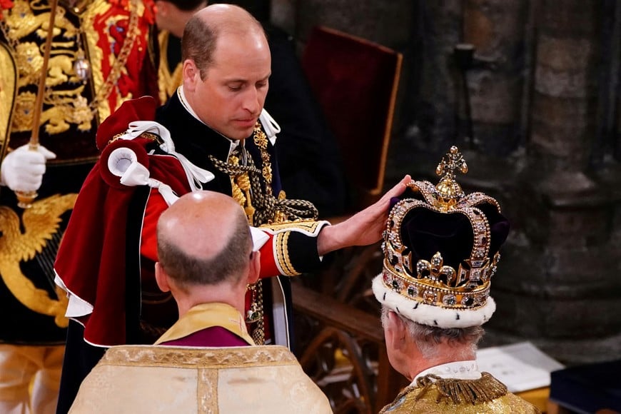 The Prince of Wales touches St Edward's Crown on King Charles III's head during his coronation ceremony in Westminster Abbey, London. Picture date: Saturday May 6, 2023. Yui Mok/Pool via REUTERS