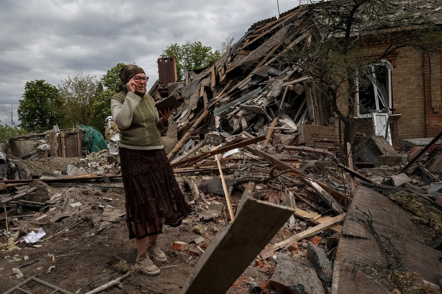 A local resident stands among remains of a house in a yard, hit by a Russian military strike, amid Russia's attack on Ukraine, in Sloviansk, Donetsk region, Ukraine May 11, 2023. REUTERS/Sofiia Gatilova