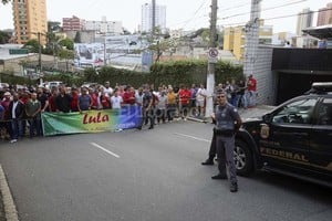 ELLITORAL_146864 |  EFE Agentes de Policía y ciudadanos con pancartas ante la residencia de Lula en la ciudad de Sao Bernardo do Campo.