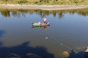 El pescador tira la malla al río y espera para recogerla con lo pescado.