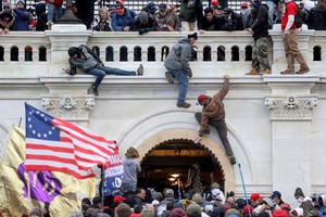 FILE PHOTO: A mob of supporters of U.S. President Donald Trump fight with members of law enforcement at a door they broke open as they storm the U.S. Capitol Building in Washington, U.S., January 6, 2021. Picture taken January 6, 2021. REUTERS/Leah Millis/File Photo
