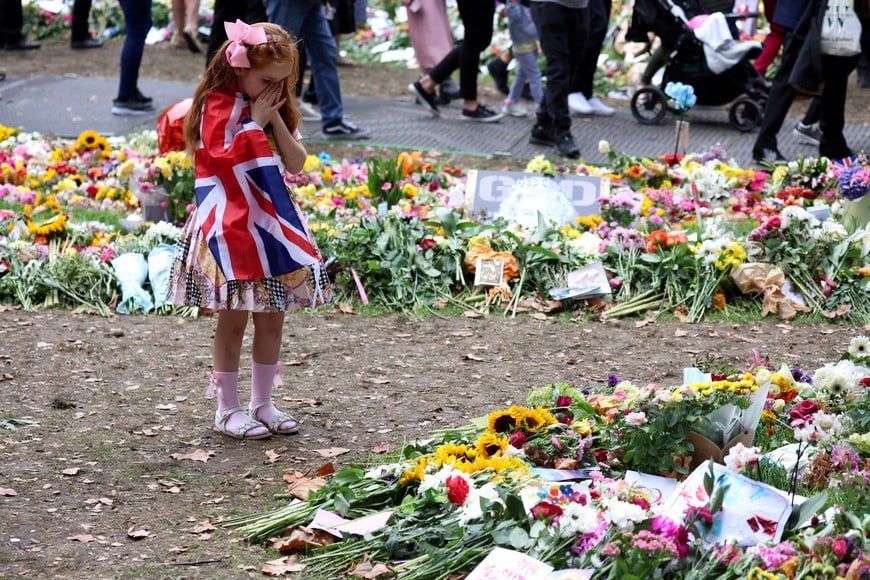 Six year old Ann Doran reats near floral tributes left at Green Park, following the death of Britain's Queen Elizabeth, in London, Britain September 15, 2022. REUTERS/Phil Noble     TPX IMAGES OF THE DAY