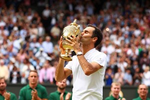 Roger Federer y el trofeo de Wimbledon, el que más veces levantó.