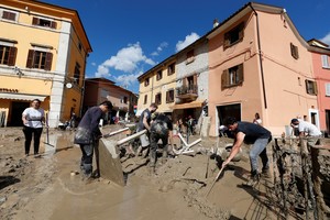 People work to clear way after heavy rain and deadly floods hit the central Italian region of Marche, in Cantiano, Italy, September 16, 2022. REUTERS/Yara Nardi