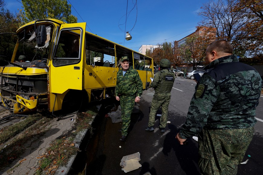 SENSITIVE MATERIAL. THIS IMAGE MAY OFFEND OR DISTURB    Service members inspect a bus destroyed by recent shelling near a local market during Russia-Ukraine conflict in Donetsk, Ukraine September 22, 2022. REUTERS/Alexander Ermochenko