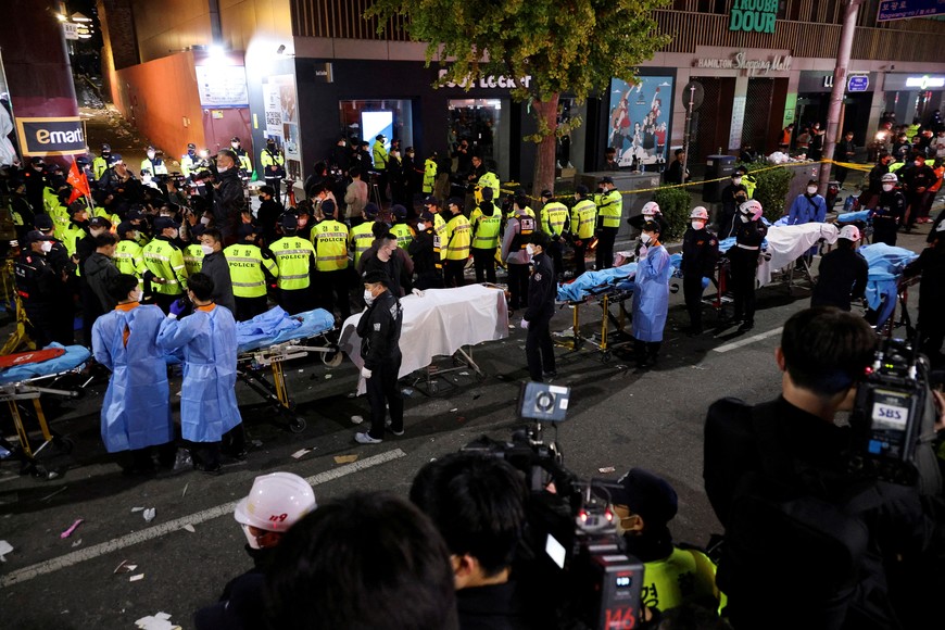 Rescue team members wait with stretchers to remove bodies from the scene where dozens of people were injured in a stampede during a Halloween festival in Seoul, South Korea, October 30, 2022. REUTERS/Kim Hong-ji REFILE - CORRECTING DATE