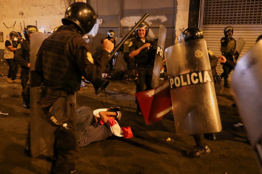 A protester on the ground takes cover as he is surrounded by riot police officers during the 'Take over Lima' march to demonstrate against Peru's President Dina Boluarte, following the ousting and arrest of former President Pedro Castillo, in Lima, Peru January 20, 2023. REUTERS/Sebastian Castaneda