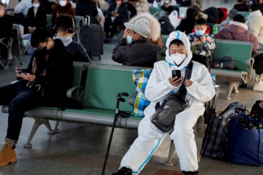 Ciudadano chino con un traje de protección sanitaria contra el Covid-19 este lunes en la estación de trenes de Beijing. Crédito: Reuters