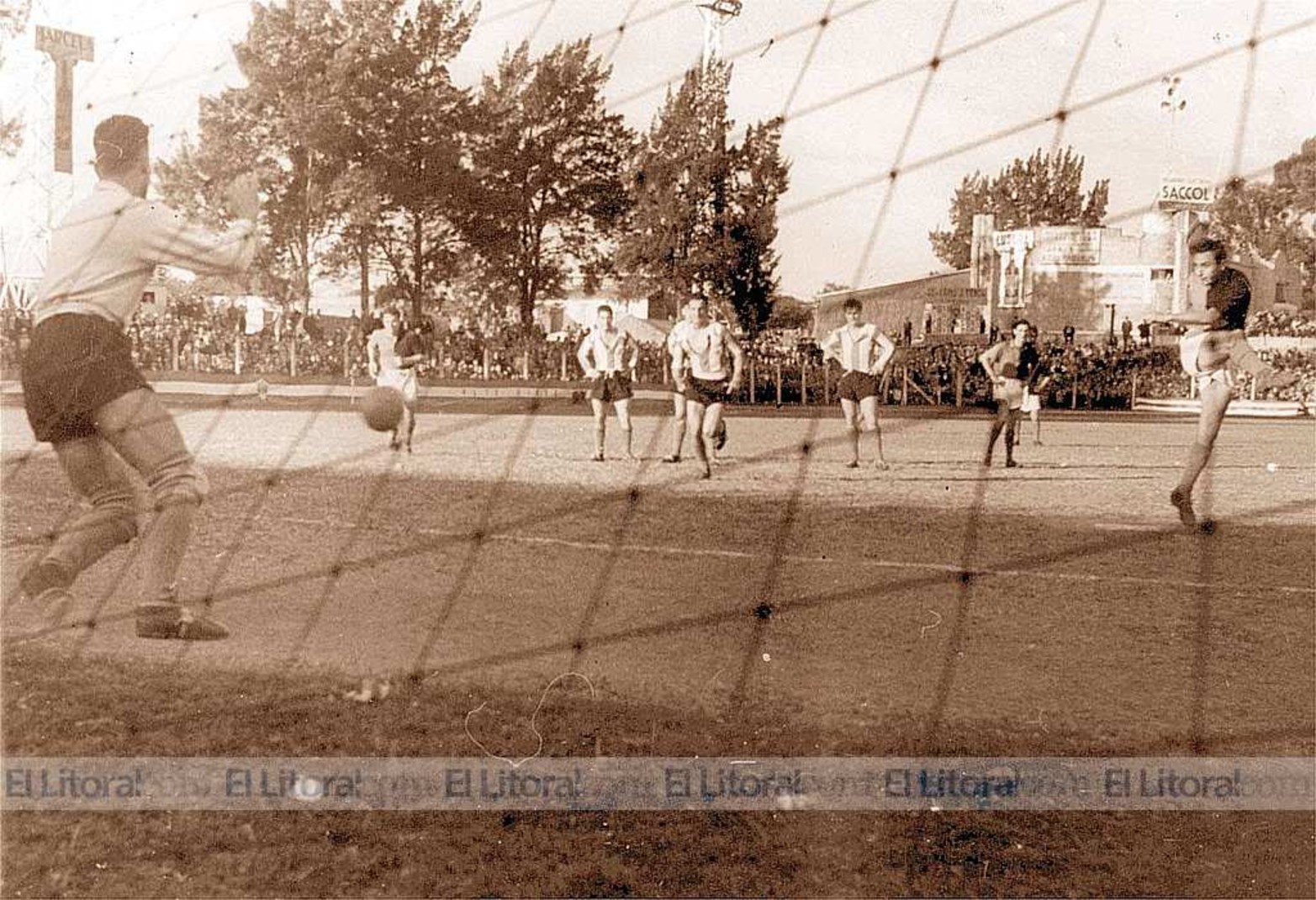 La tribuna de los pinos. Lo que se observa de fondo es el sector de Cándido Pujato en la cancha de Unión. El que patea es Olivera y el que ataja es Nanzer. Fue en mayo de 1955, año con muchos hechos históricos en nuestro país.