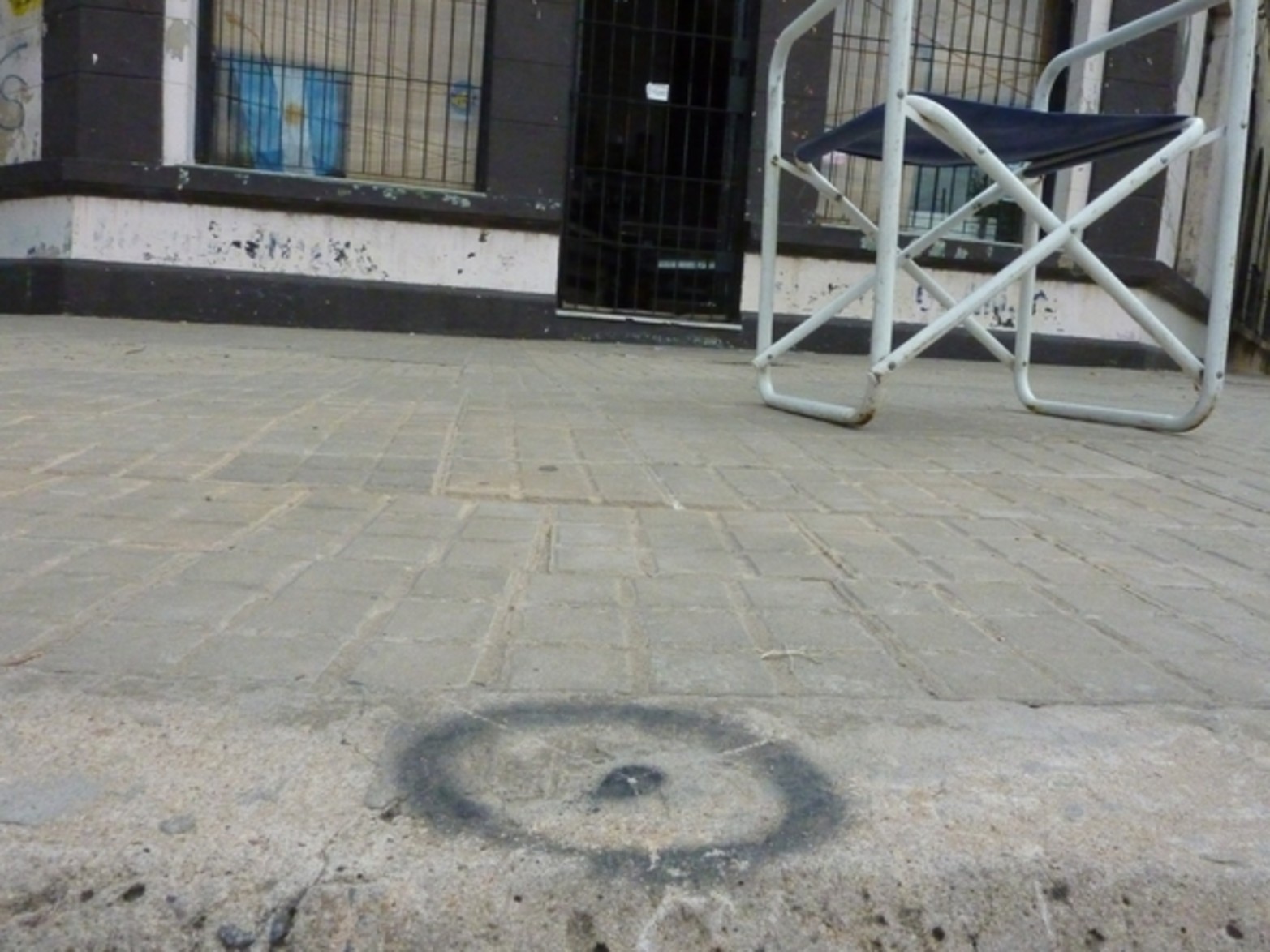Un circulo negro con un punto en el centro, pintado con aerosol; la misteriosa marca.