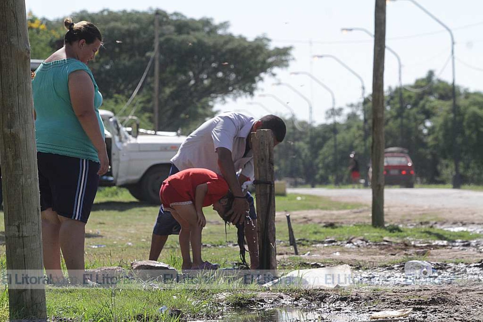 A lavar la cabeza. Aprovechando las altas temperaturas, este padre le lava la cabeza a su hija.