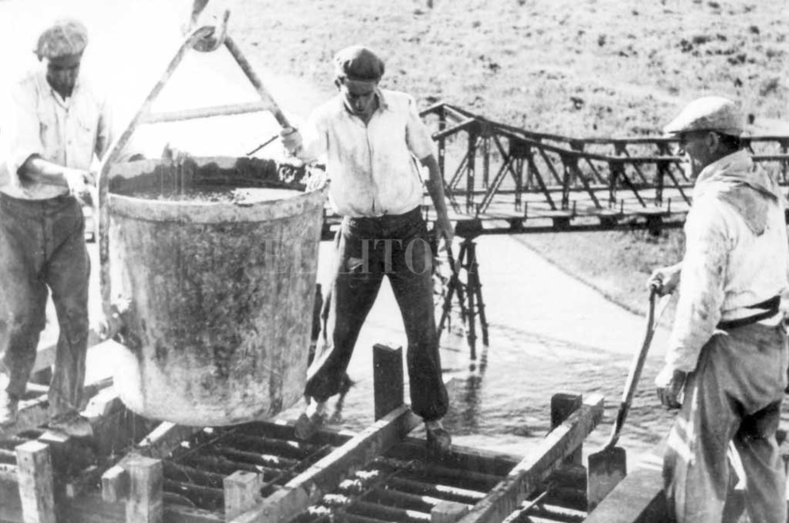 Antecesor. Imagen de la construcción del Carretero, en la que se ve el viejo puente de hierro. En la actualidad aún se pueden observar los antiguos pilares, hoy de utilidad para muchas personas que los usaron como base para levantar sus viviendas.