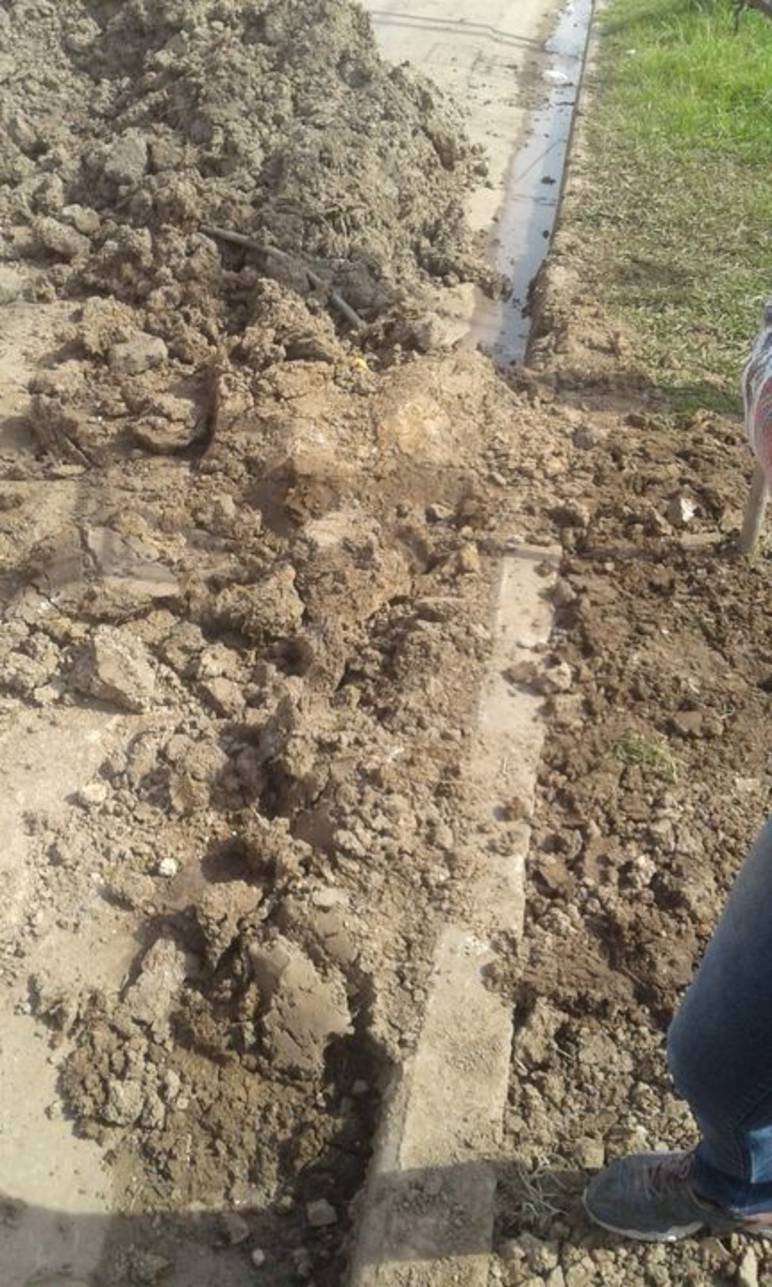 Los escombros de la intervención obstruyen el cordón cuneta.