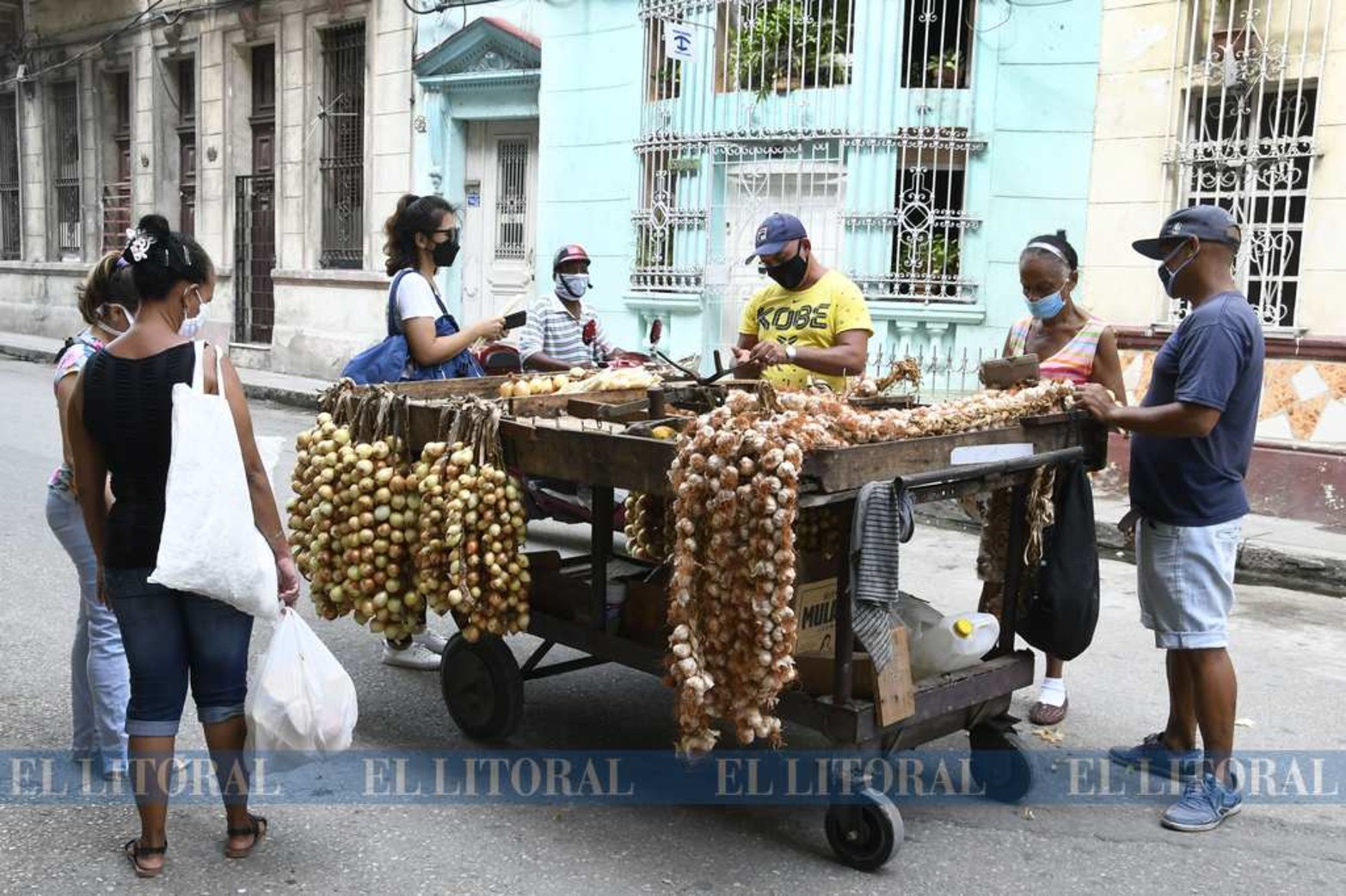 Cuba propone tapabocas y distanciamiento. Compra de alimentos a un vendedor ambulante.