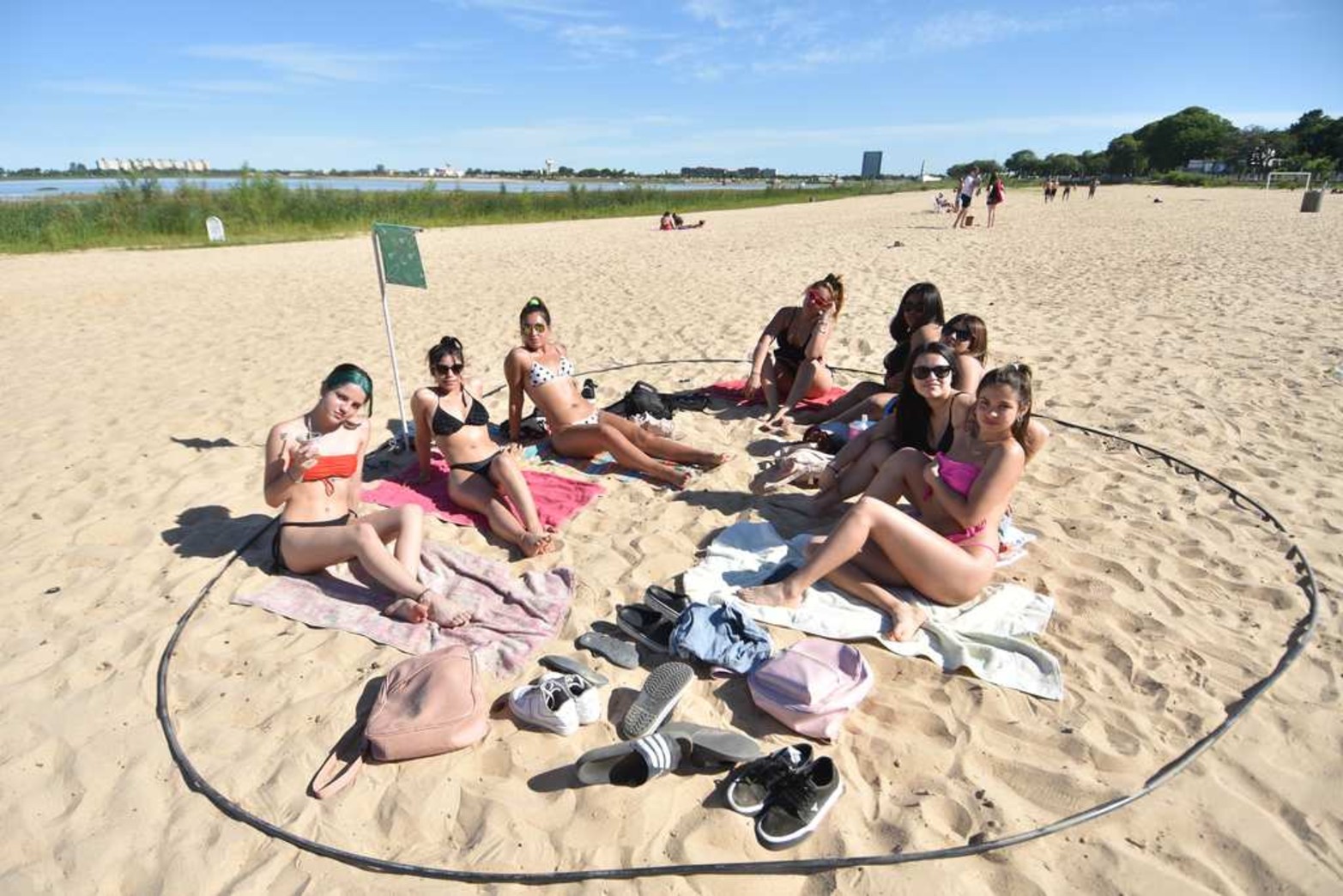 A la playa... pero con distanciamiento. La "nueva normalidad" en la costanera para disfrutar del sol cerca del agua: círculos demarcados en la arena para delimitar los sectores a ocupar por grupos reducidos de personas.