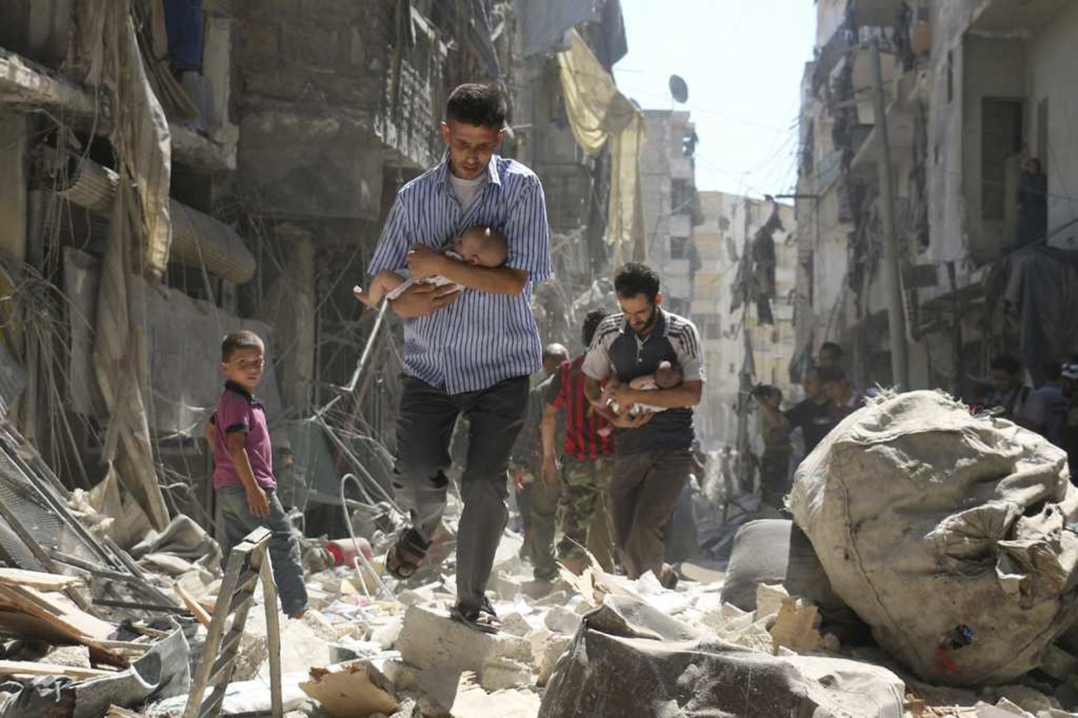 Segundo premio de Historias en la categoría de Noticias de Actualidad, captada por el fotógrafo Ameer Alhalbi de la Agence France-Presse (AFP). La imagen, titulada "Rescued From the Rubble", muestra a dos hombres sirios mientras rescatan a dos bebés de una zona destruída tras un bombardeo en Alepo, Siria, el 11 de septiembre de 2016.