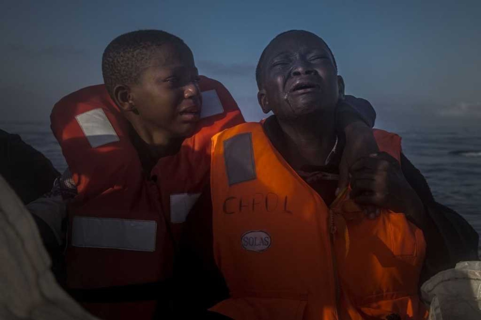 Imagen tomada por Santi Palacios ganadora del segundo premio en la categoría "Temas de Actualidad" de los premios World Press Photo. La imagen muestra a dos hermanos nigerianos, una niña de 11 y un niño de 10 años, que lloran a bordo de un barco de una ONG que les rescató en alta mar el 28 de julio de 2016. Los pequeños navegaron durante horas en una patera junto a otros refugiados y fueron localizados a 23 kilómetros de la costa libia. Ambos menores dijeron que su madre había fallecido en Libia.