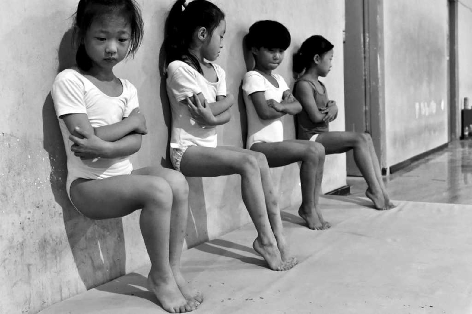 Tomada por el fotógrafo Tiejun Wang, ganadora del segundo premio de la categoría "Vida Cotidiana" de los premios World Press Photo. En la imagen, llamada "el sudor fabrica campeones", aparecen cuatro estudiantes de la escuela de gimnasia que realizan flexiones de pie durante un entrenamiento de media hora en Xuzhou (China).