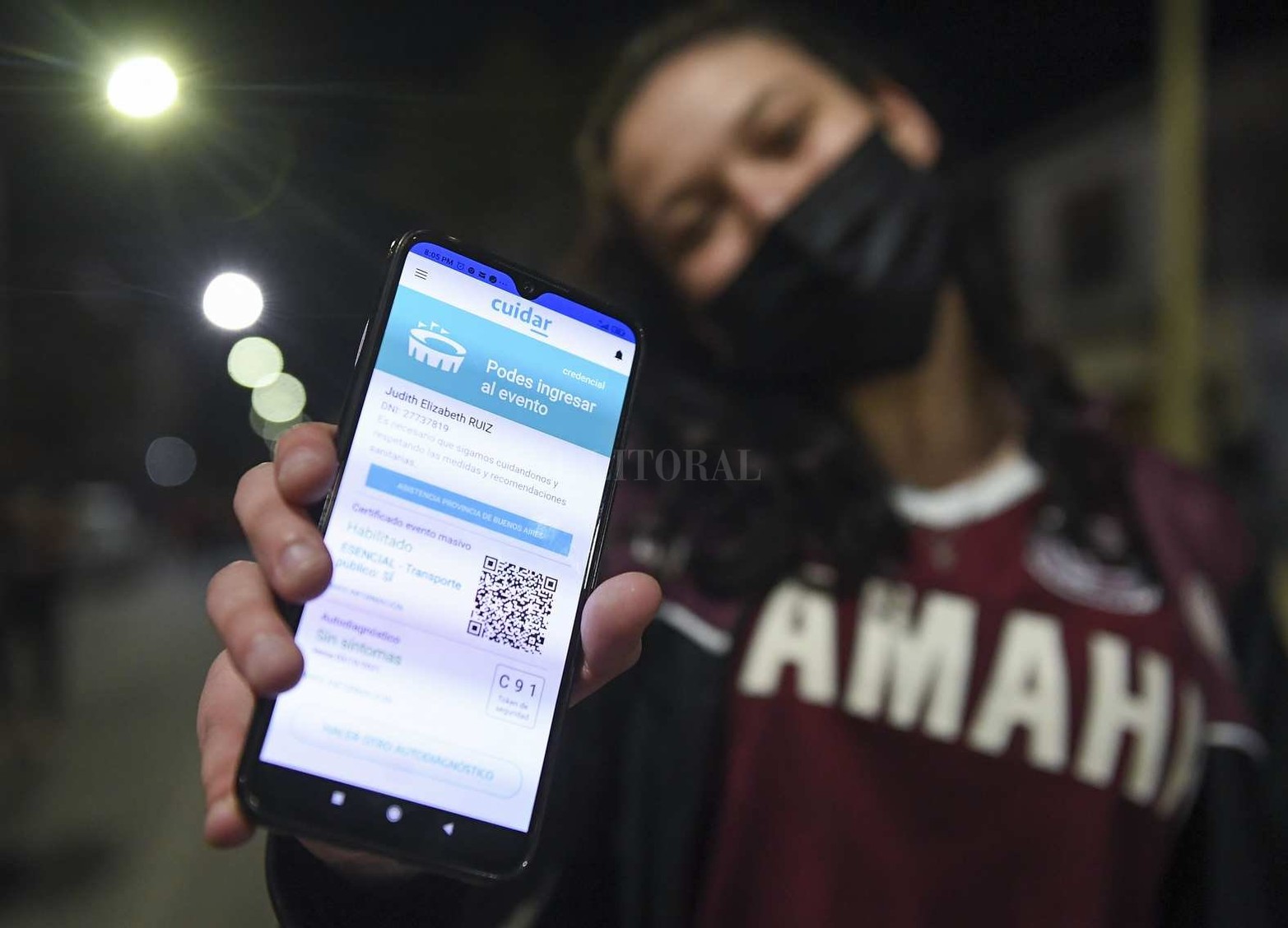 Hincha de Lanús mostrando uno de los requisitos: La autorización de asistir al evento con la APP Cuidar.