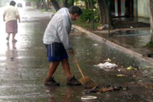 ELLITORAL_732 |  Mercedes Pardo. Vecinos intentan limpiar las alcantarillas al comenzar la lluvia en barrio Alfonso.
