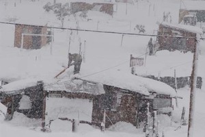 DyN Apenas se puede observar, tras el velo de nieve, la figura de un sujeto intentando quitarla de su hogar.