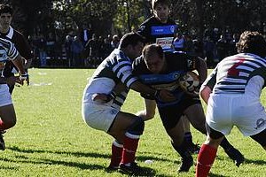 Néstor Eduardo Juncos Galo Della Vedova, capitán del flamante bicampeón, intenta atravesar el intento defensivo de Carlos Ripani y Tomás Comba, mientras llega el apoyo del medio scrum Magín Moliné. La imagen se completa con Franco Manavella y el referee Mauro Rivera.