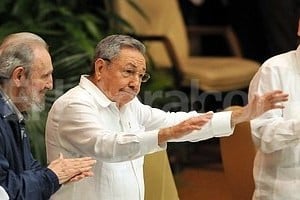 EFE Fidel Castro y el vicepresidente de Cuba, flanquean a Raúl Castro (con los brazos extendidos) al ser elegido primer secretario del Partido Comunista de la isla.