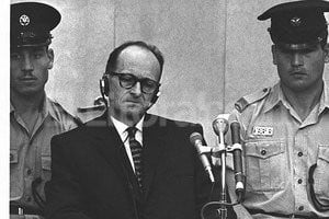ELLITORAL_56472 |  Archivo El Litoral Eichmann, flanqueado por policías israelíes, asiste dentro de un cubículo de seguridad, al desarrollo de su juicio por el exterminio de judíos en la ciudad de Jerusalén.