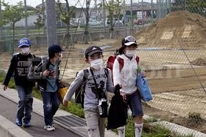 ELLITORAL_57509 |  EFE Alumnos caminan de regreso a casa, mientras las grúas retiran la tierra expuesta a la contaminación en su colegio.